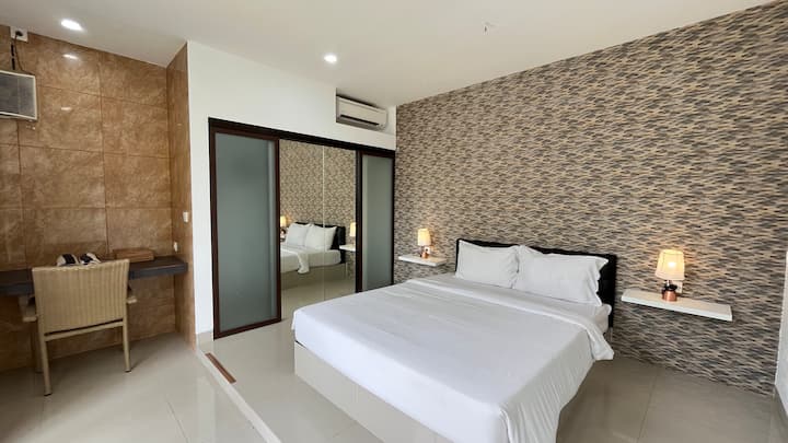 Amplio segundo dormitorio principal con elegante pared decorativa y privacidad adicional.