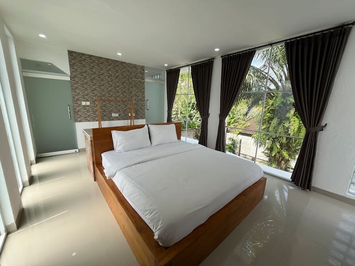Dormitorio en el piso superior con balcón privado y exuberantes vistas tropicales.