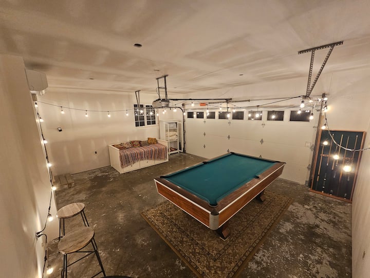 Cochera climatizada y sala de juegos, con un sofá cama individual que se convierte en una cama tamaño king, con capacidad para dos personas.