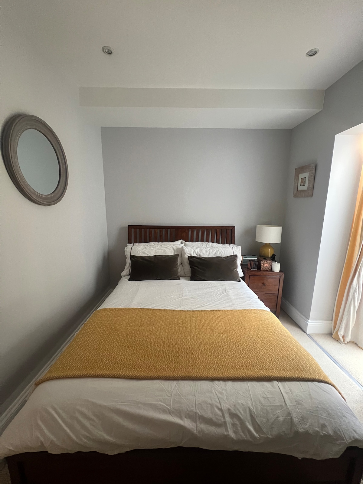 Cama doble, con mesita de noche, que conduce al vestidor y entrada privada al jardín. 