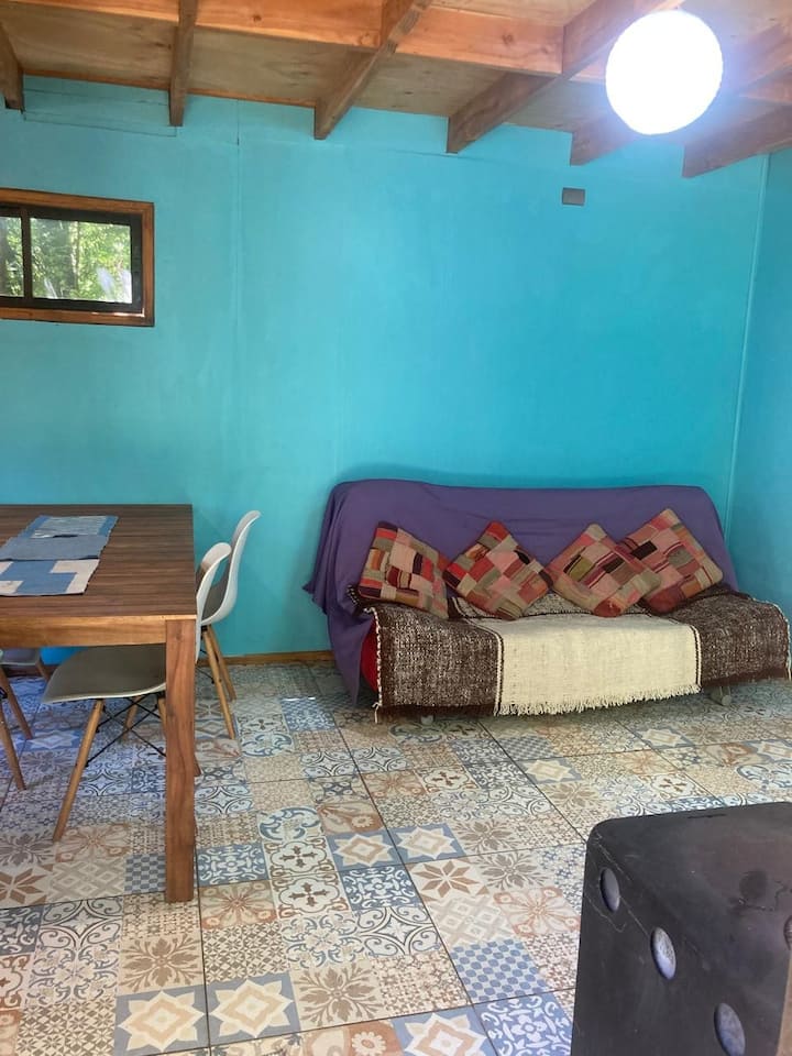 Ni ghorofa ya kwanza, ya mazingira ambapo kitanda cha sofa, chumba cha kulia na jiko viko upande wa kushoto kabisa wa picha hii.
Eneo hili linaweza kupashwa joto kwa jiko la mwako polepole, au kipasha joto cha umeme ikiwa haliruhusu kuweka moto.
