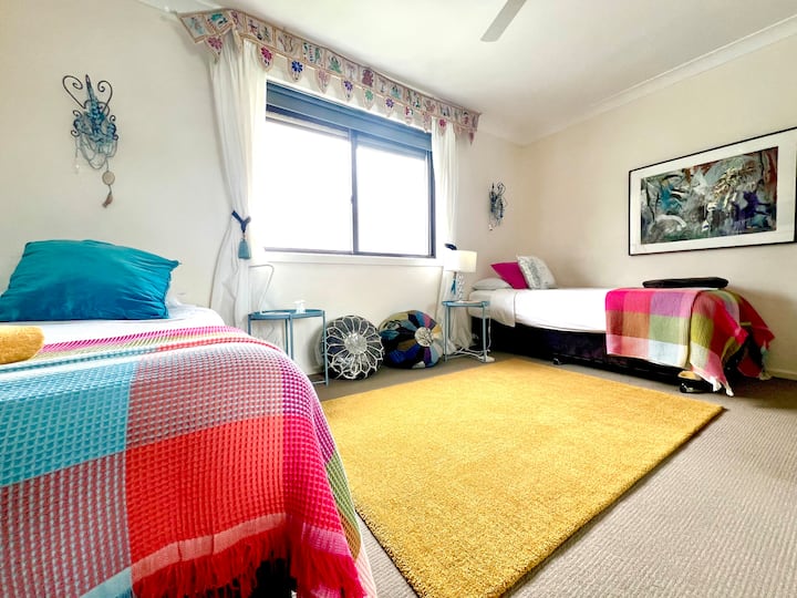 Large west facing room with views over the national park and green hills of Newport.
A third single mattress fits comfortably on the floor in the middle of the two single beds.
Ample room for yoga.
Single beds can be made into a king bed on request.