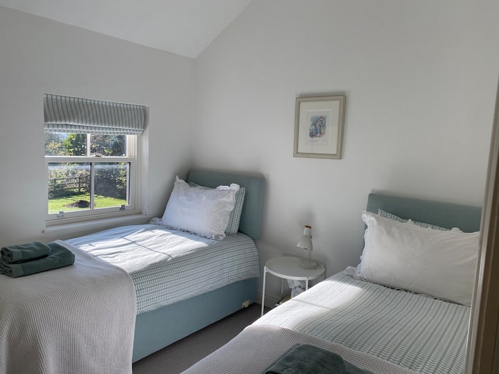 Bedroom 2 with zip and link bed that can be 2 standard single beds or 1 Super King.  This room contains a wardrobe with side drawers, a mirror, chair and bedside table. Heating is provided via a radiator.