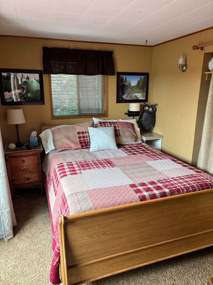 Dormitorio tamaño queen con TV y puertas corredizas con vistas al patio.