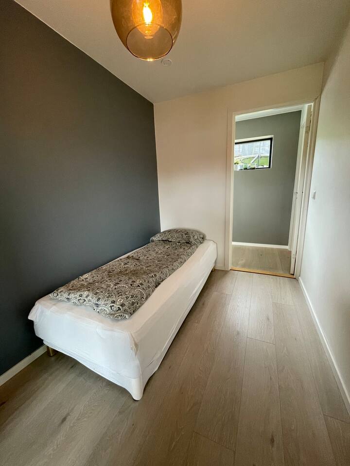 Dormitorio con una cama de una plaza.
Pared en la pared con dormitorio principal.
