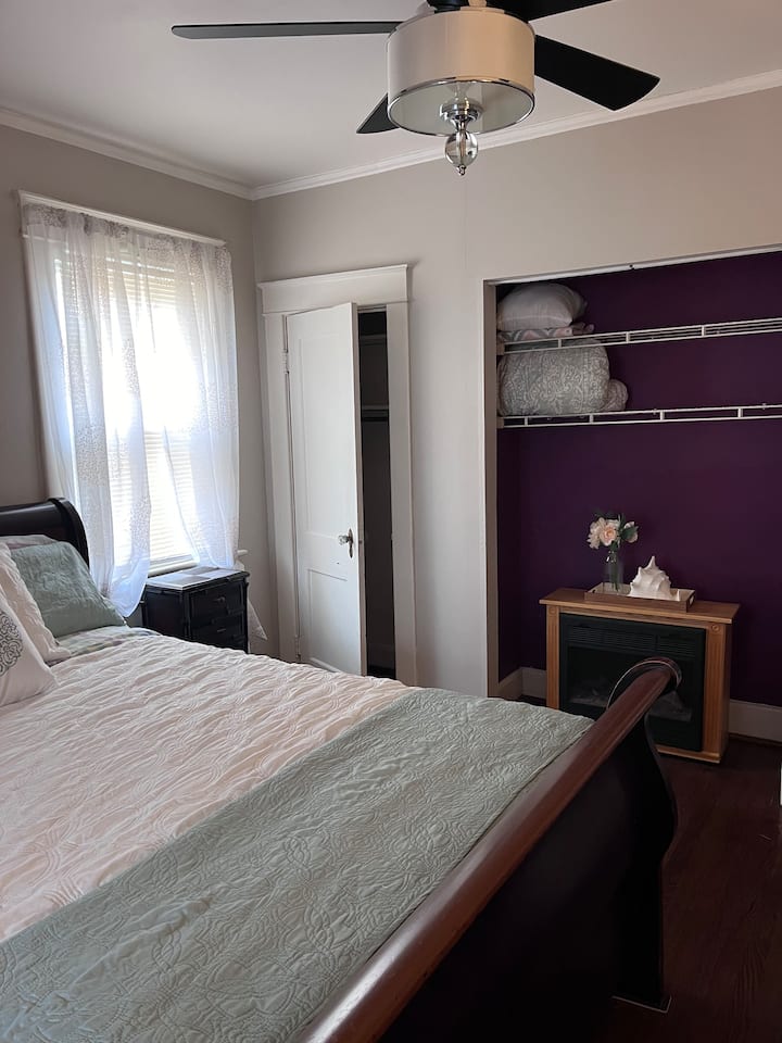 Queen bed, sitting chair, decluttered dresser, night stand and closet for full usage,  tv mounted on wall, overhead ceiling fan, 1/2 bath and walk-in closet and electric fireplace.   