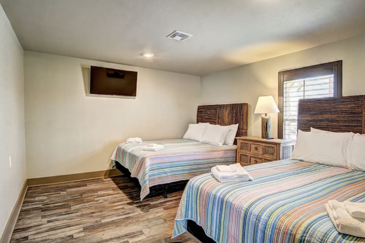Unwind in your comfortable twin bedroom featuring fresh linens, warm lighting, and modern amenities for a restful stay.