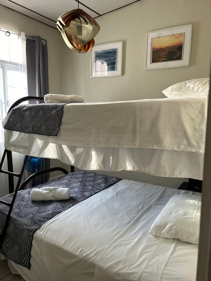 Habitación n .º 3 
Litera, con una cama individual en la parte superior y una cama tamaño queen en la parte inferior, iluminación acogedora para un descanso tranquilo.

Este dormitorio tiene un mini aire acondicionado dividido para tu comodidad. Temperatura sugerida 70F/21 C para evitar que se derrita. 