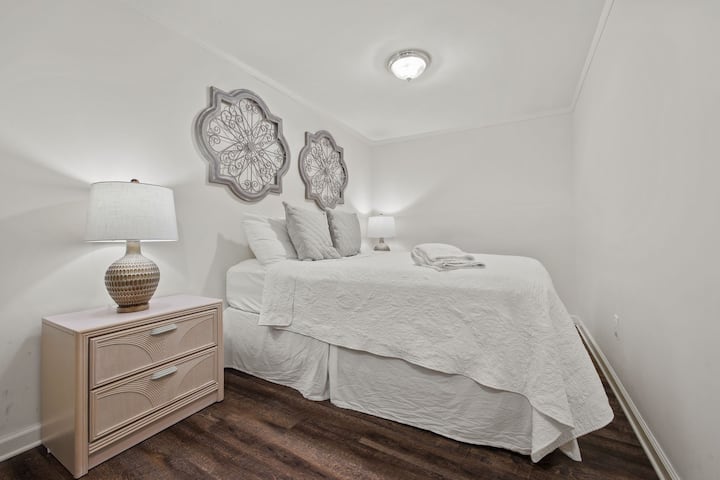 Dormitorio de la planta baja con una cama tamaño queen, literas y baño privado.

Este dormitorio dividido conecta el salón de la planta baja con el hueco de la escalera. Para caminar desde el salón de la planta baja hasta la planta de arriba, tendrás que pasar por el dormitorio dividido.