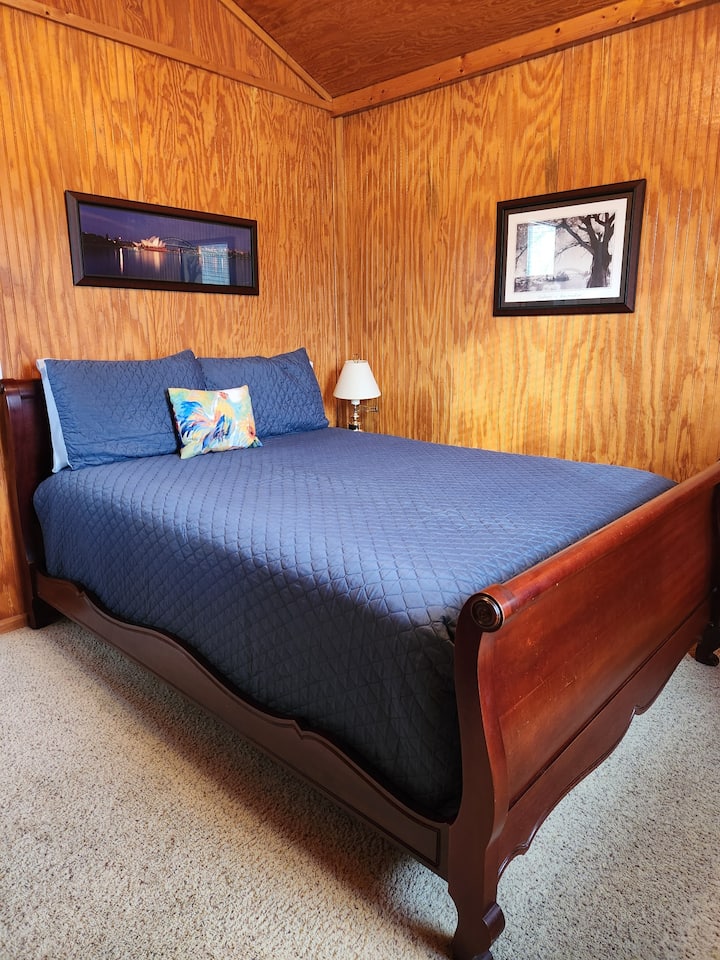 Queen size sleigh bed has comfortable mattress.  A matching dresser (not pictured) has additional sheet sets and quilts for the queen size bed.