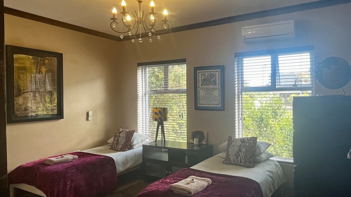 Habitación con dos camas individuales y baño privado con ducha