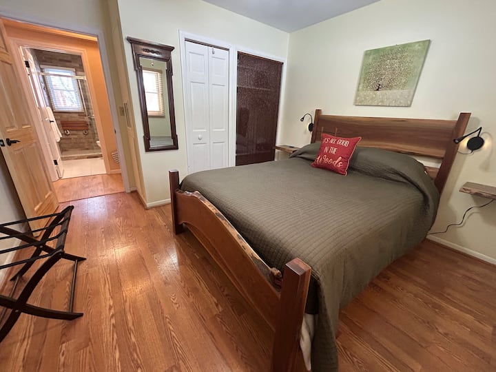 Live-edge walnut bed created in our own woodshop, with adjustable reading light and handy power supply on both sides