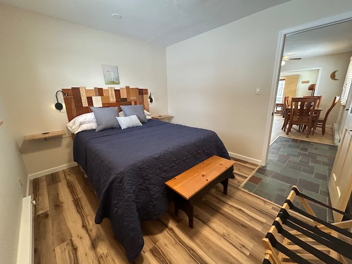 Mosaic bed of many woods, created in our woodshop. Adjustable reading lights and handy power supply on both sides of bed.