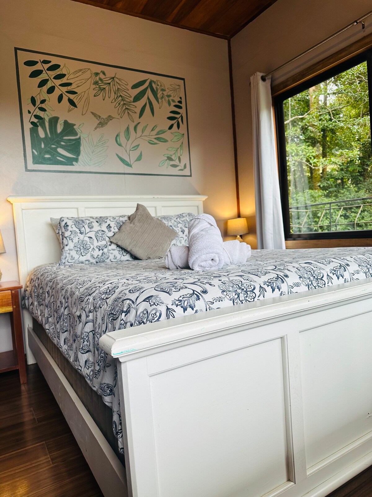 Cama tamaño queen con una ventana que da a los árboles, dejando entrar luz suave y vistas al bosque. Los huéspedes a menudo mencionan lo tranquila que se siente la habitación, especialmente por las mañanas.