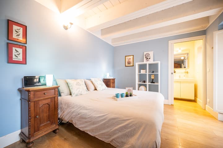 Chambre double avec murs bleus, lit double et atmosphère relaxante.