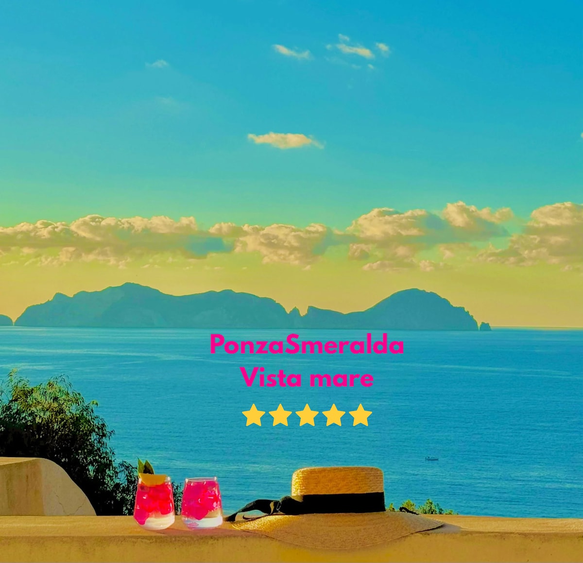 Two colorful cocktails sit on a stone ledge, overlooking a breathtaking view of the sea and distant islands. The sky is a blend of soft blue and golden hues, reflecting a tranquil atmosphere. The horizon showcases gentle waves under a cloud-studded sky.