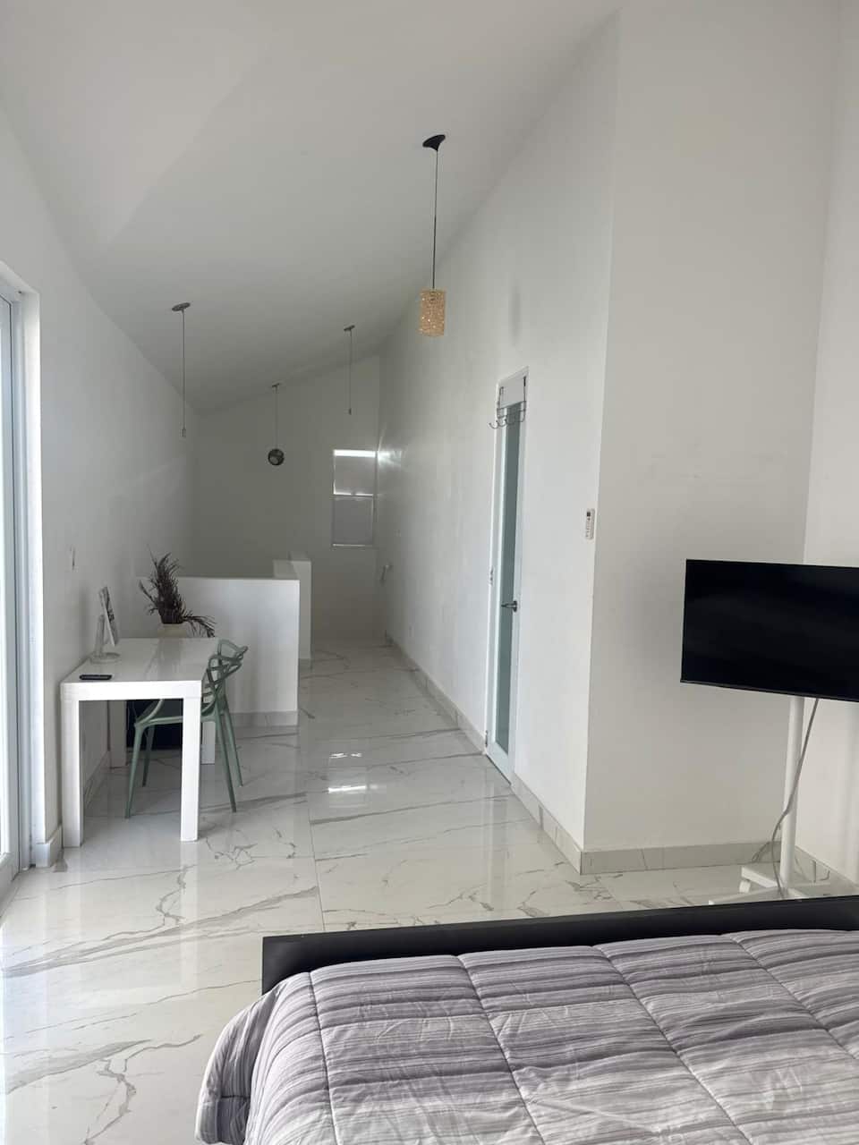 Studio interior with bed, desk and television