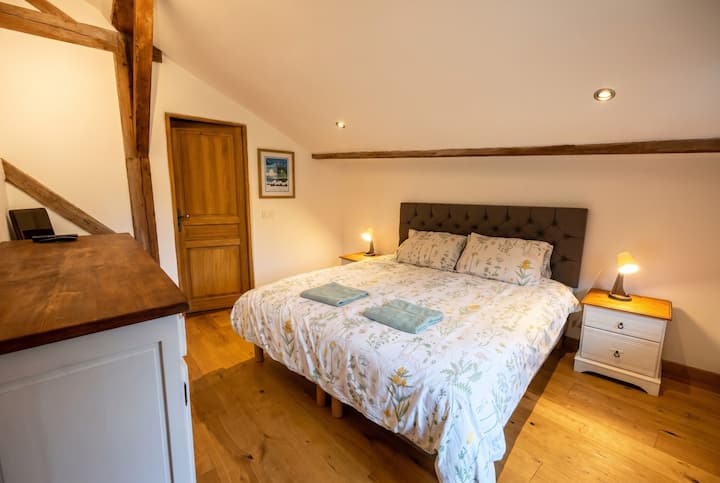 Détendez-vous sous les poutres rustiques de cette chambre paisible, où vous attendent de douces serviettes fraîches.