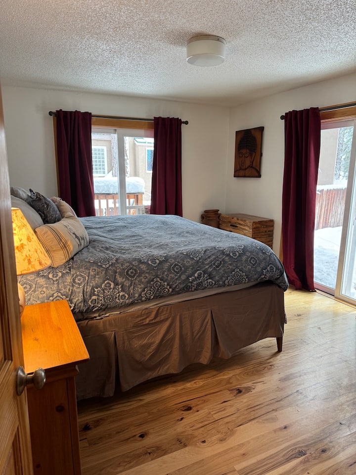 Downstairs bedroom recently updated with a King Tempurpedic bed, Sliding glass doors open to the unlandscaped backyard.  There is a doggie door to the backyard for our furry guests.