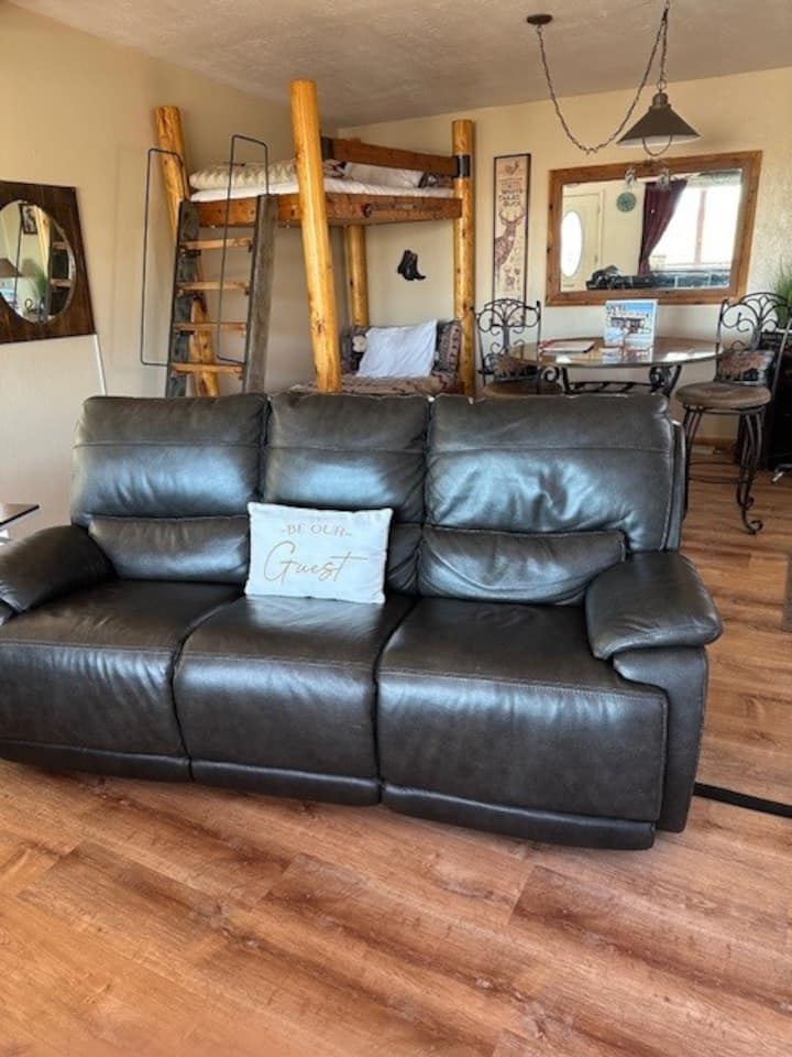 Brand new Leather Couch-Electric! (And new flooring 4/2026) Behind the couch is a bunk bed and a 2nd dining room table). (DO NOT talk or interact with the horses next door!)