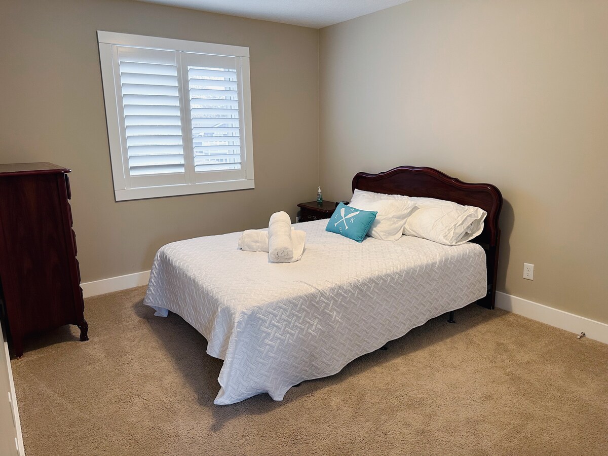 Cama tamaño queen ubicada en un dormitorio en el nivel superior. 