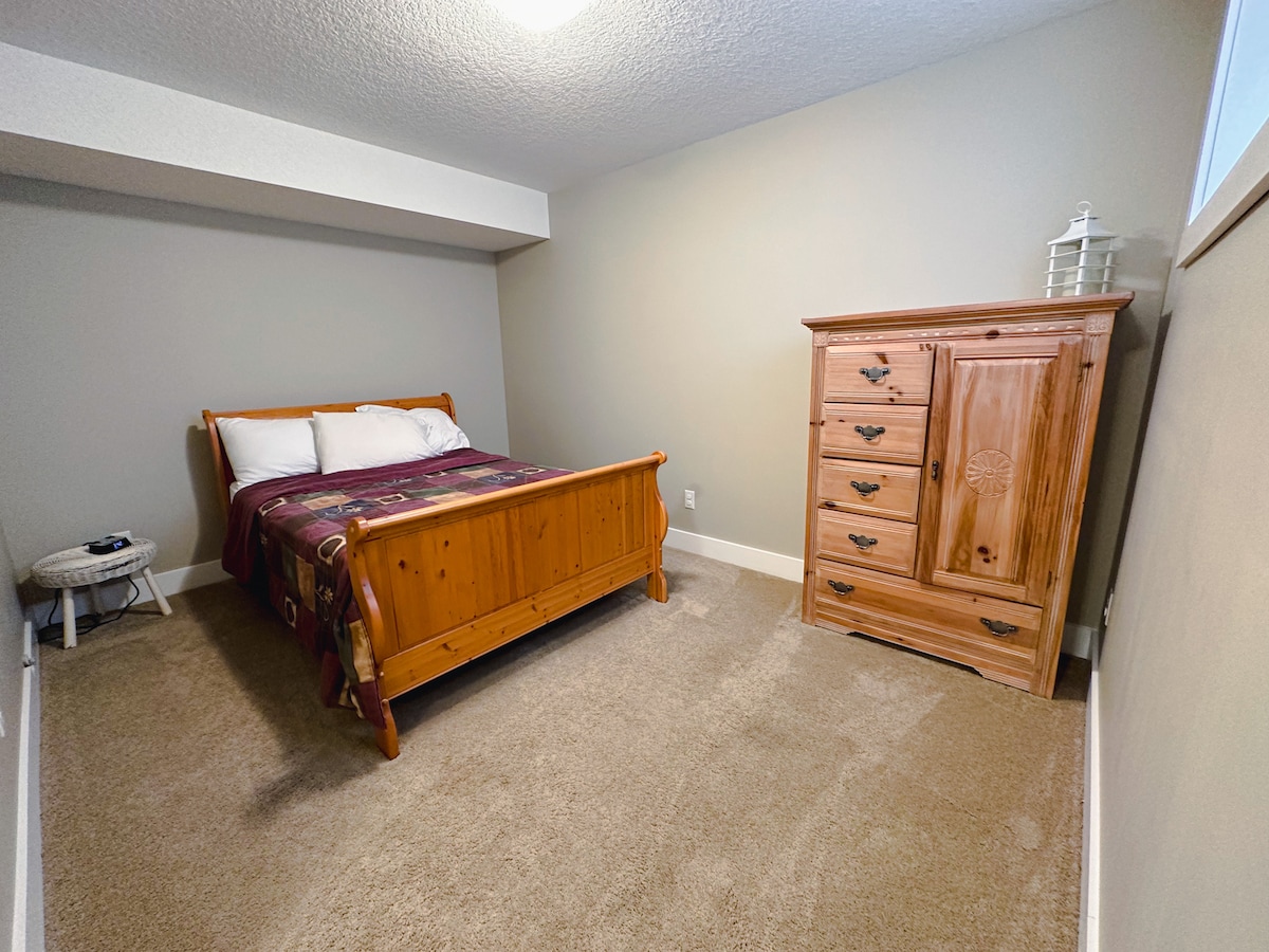 Cama tamaño queen disponible en el espacioso dormitorio del sótano. 