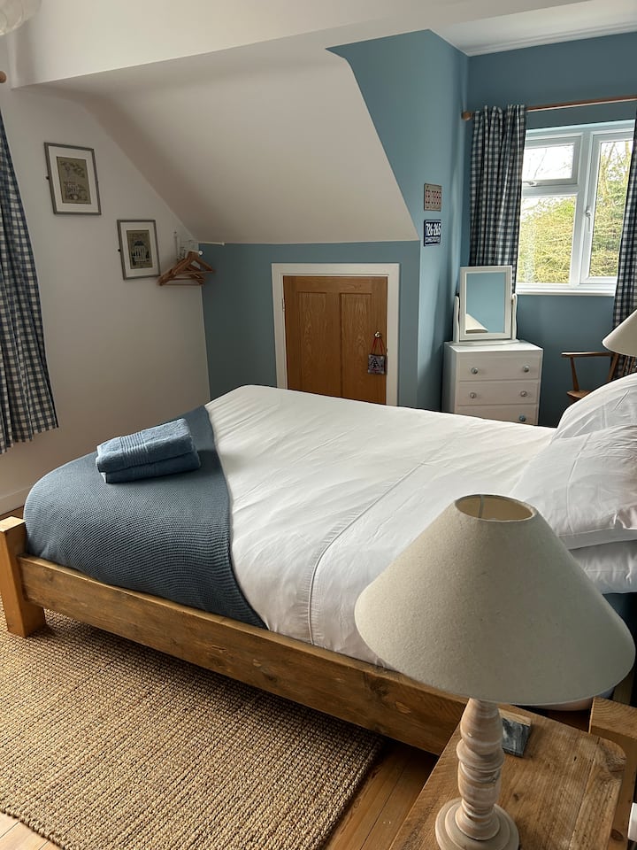 UNC. Colours inspired by North Carolina’s University. A large bright bedroom with storage space and a king sized bed