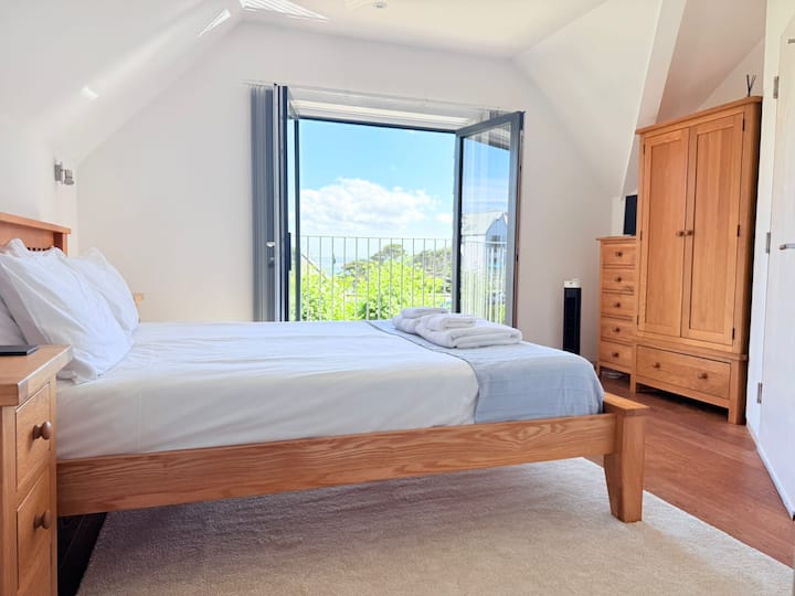 Bedroom 2 with Kingsize bed. Sea view from the French doors overlooking the South Facing garden.