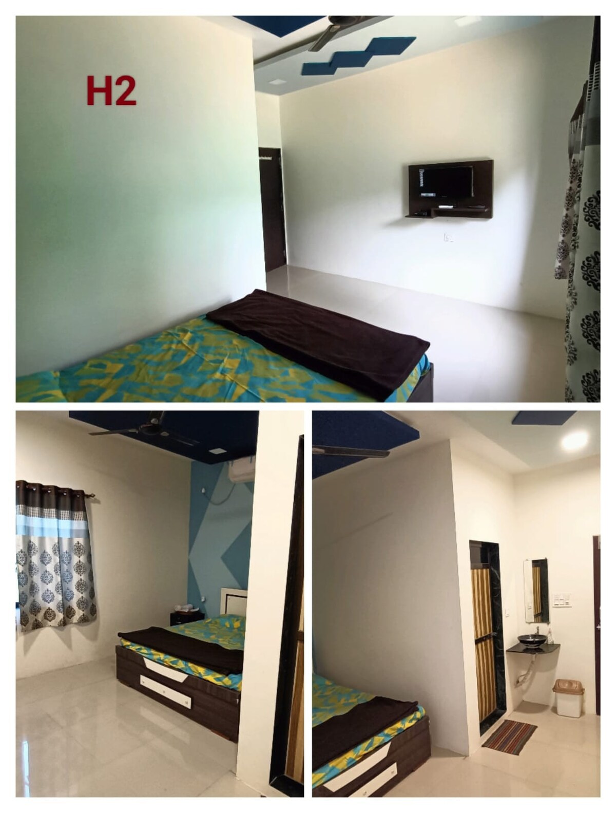 A well-furnished private room features a king-sized bed with a vibrant blue and green patterned bedspread. A television is mounted on the wall opposite the bed. Natural light enters through a window with decorative curtains. An attached bathroom is visible, equipped with essential amenities.