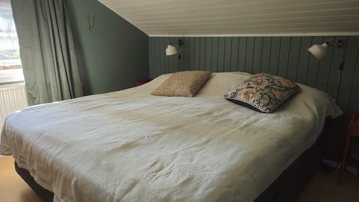 Tweepersoonsbed 180 cm in slaapkamer boven met schuin plafond. 