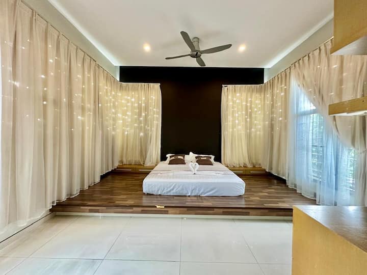 Notre chambre principale de style tatami offre une retraite tranquille et spacieuse, avec un grand lit king size et un éclairage doux. De grandes fenêtres avec des rideaux conçus laissent entrer la lumière naturelle, créant une ambiance paisible. Détendez-vous et détendez-vous avec style