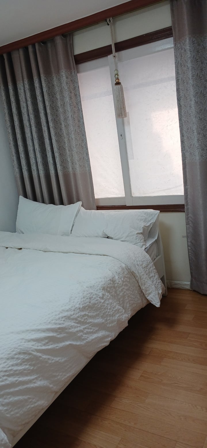 เตียงควีนไซส์และม่านบังแสงในห้องนอน 1