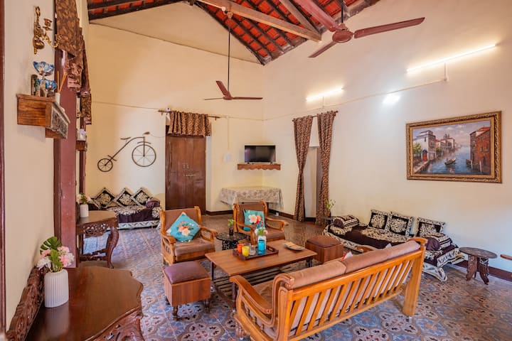 The living room has a TV, a table, coffee tables, grandfather chair and more.
