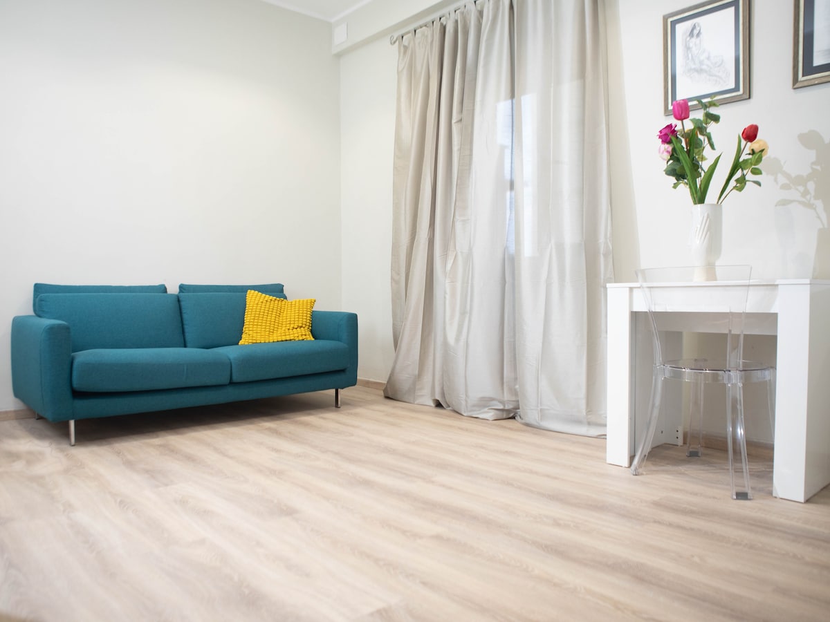 Moderná a svetlá obývacia izba v srdci mesta Viterbo s modrou pohovkou, klimatizáciou, TV a jedálenským stolom. Ideálne miesto na oddych po dni strávenom v uliciach historického centra alebo v Terme dei Papi.
