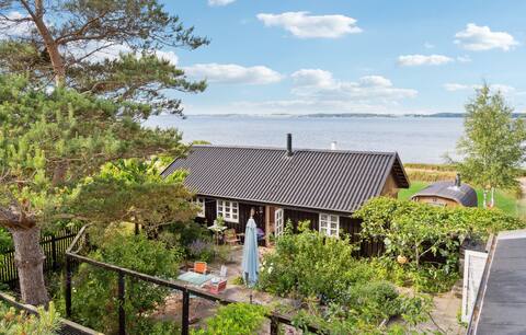Idyllic black cottage first row to the sea