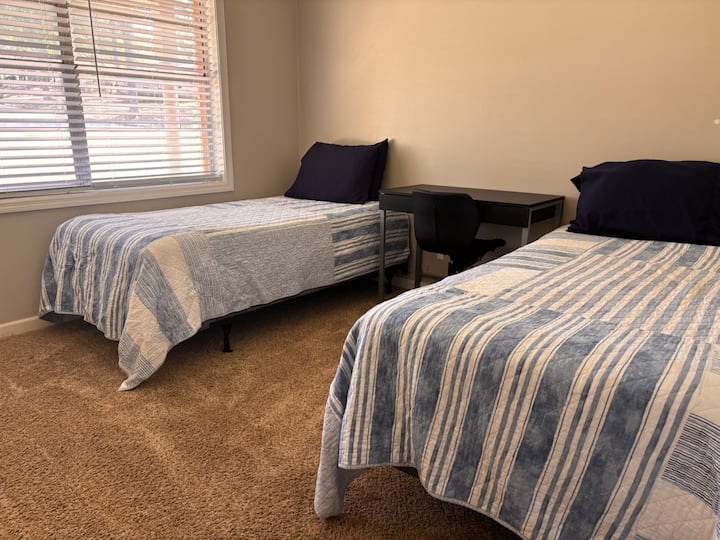 מיטות יחיד ושולחן בחדר השינה 3.  בשתי המיטות יש מזרני קצף זיכרון