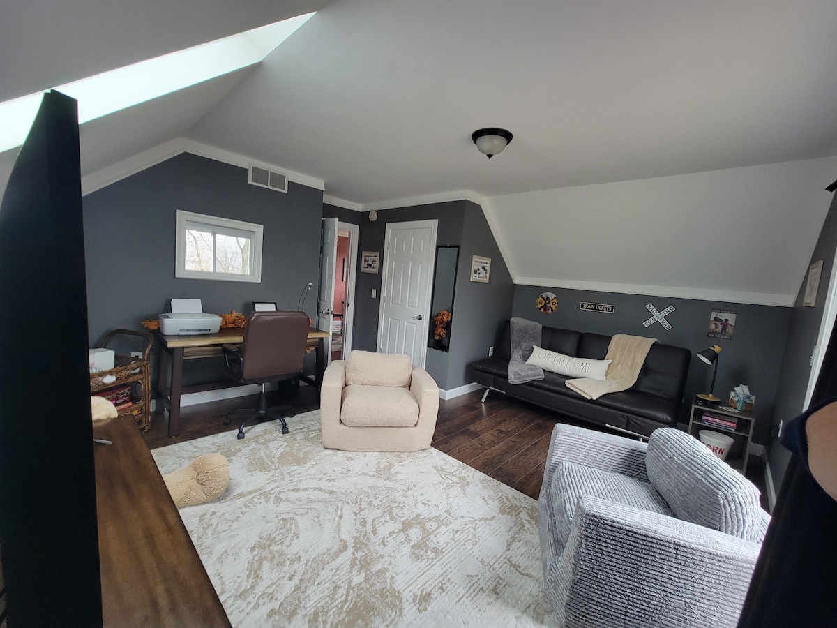 Sillas cómodas y un sofá/futón de cuero.  Sala de juegos y oficina arriba