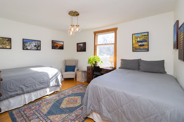 This bedroom features two comfortable queen beds and a dedicated workspace, making it perfect for groups to relax, recharge, or catch up on a bit of work if needed.
