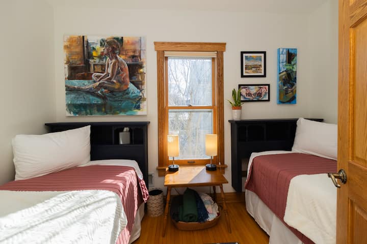 This charming room features two twin beds, perfect for kids yet comfortably suited for adults, offering a cozy and versatile space for any guest.