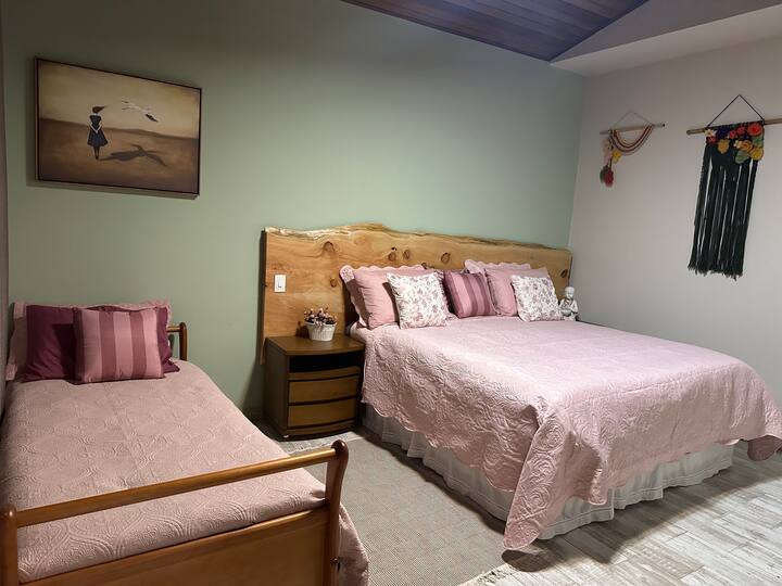Suíte com cama king de casal e uma confortável cama box de solteiro. Quarto amplo com armário, espaço pra café , e banheiro amplo. Suite com entrada privativa !