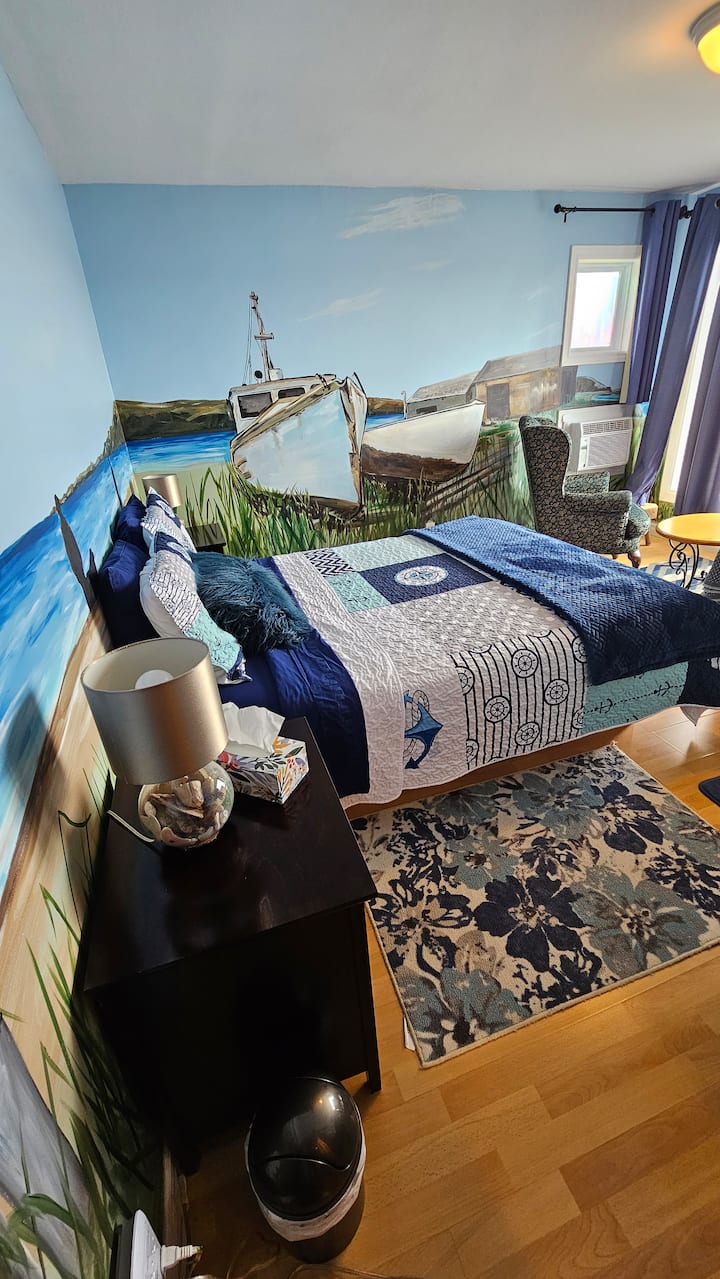 Dhomë me pamje nga fjordi Saguenay, me dekor buzë detit me far të ndriçuar, krevat dopio dhe lindje dielli.