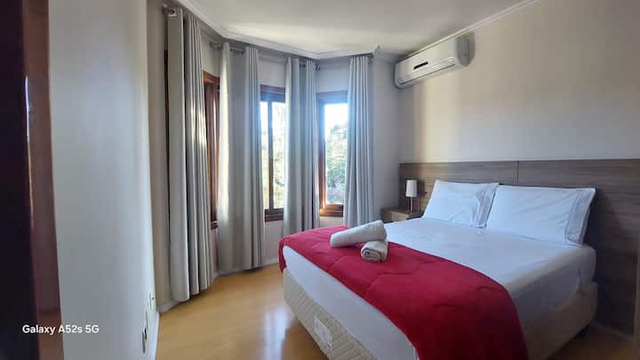 Quarto  suíte 1° piso, cama casal com local para guardar roupas, cortinas black-out. Com ar condicionado e enxoval de cama e banho com cobertas extras.