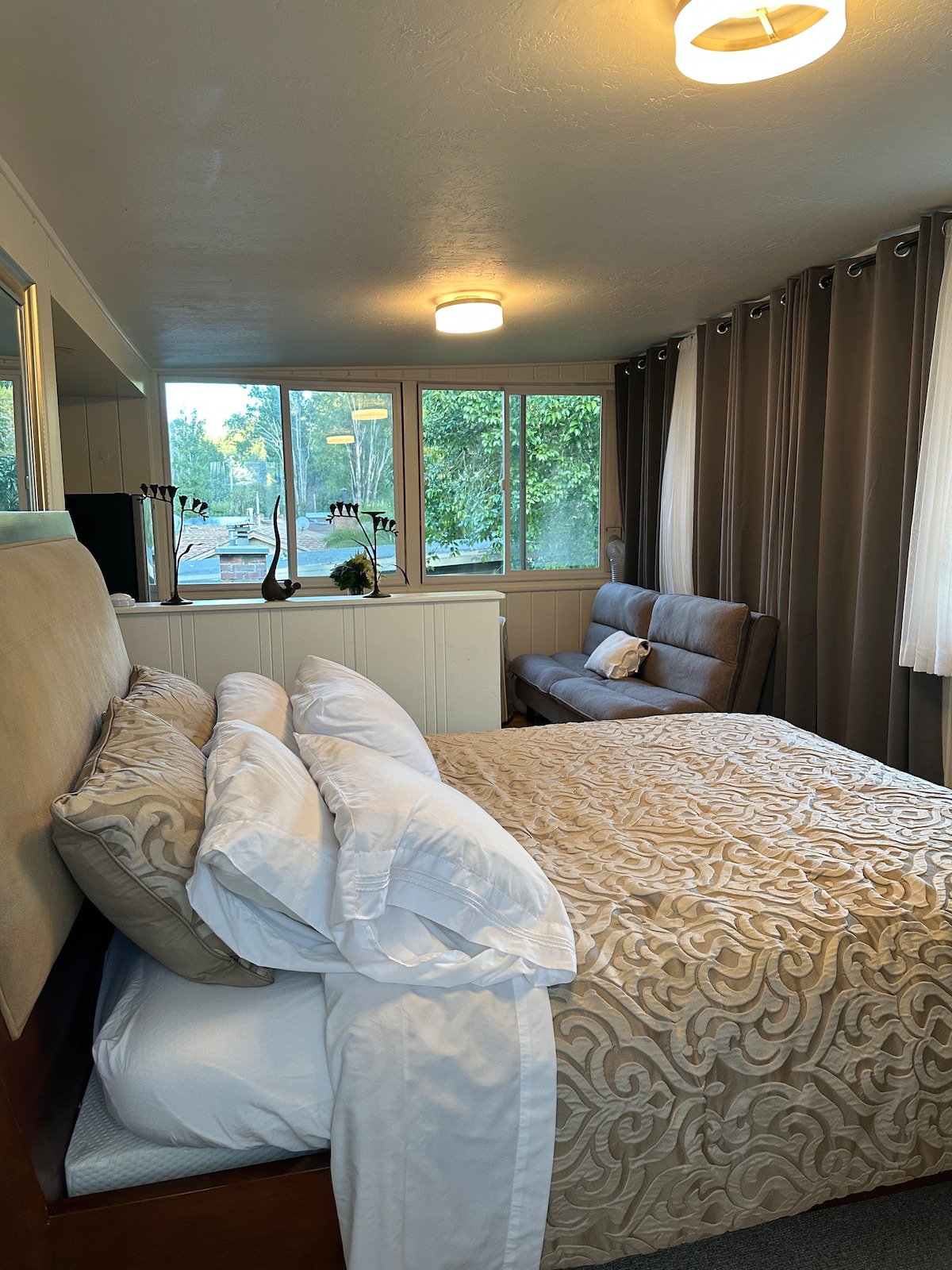 Dormitorio 4 con cama tamaño queen, sofá pequeño y zona de cocina 