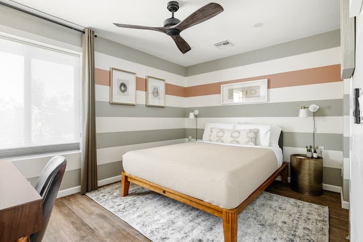 Agate Room with queen Casper bed and horizontal stripe accent wall in desert tones.