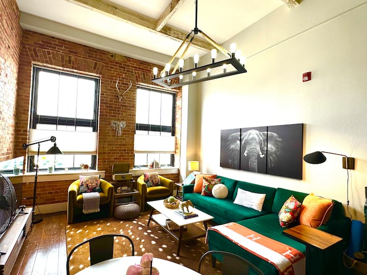 Espace de vie conçu en gardant le confort à l'esprit à l'esprit. Télévision roku 65". Des murs en briques apparentes et immenses fenêtres. Canapé sectionnel luxueux et confortable en velours à feuilles persistantes !