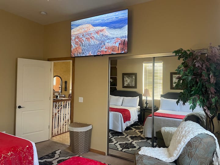 Втората спална соба има два  кревета и 65 инчен телевизор. 