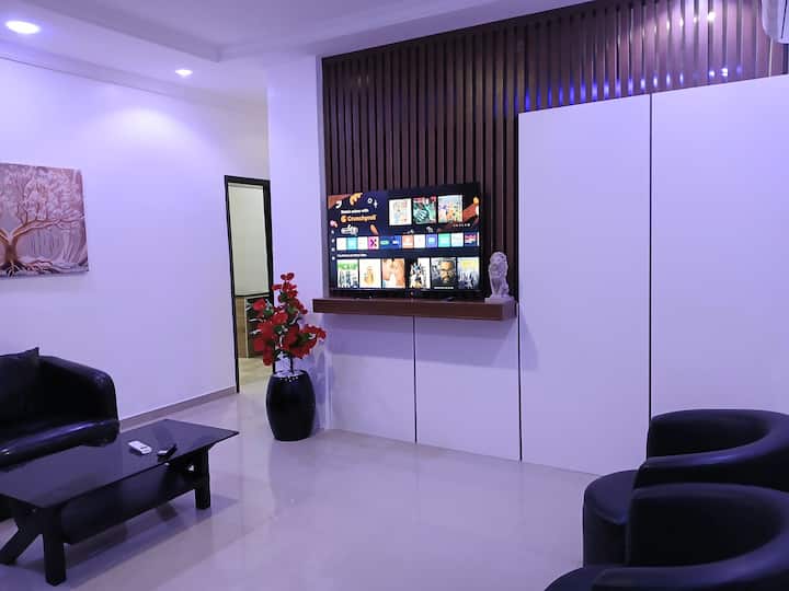 dizajn modern, bashkëkohor që tregon hapësirën tënde të ndenjjes, televizor inteligjent 55 inç, ndenjëse lëkure dhe dysheme mermeri të bardhë.