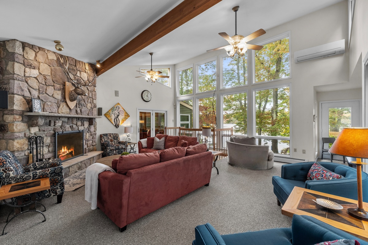 Gran habitación con ventanas de piso a techo con vistas al lago.