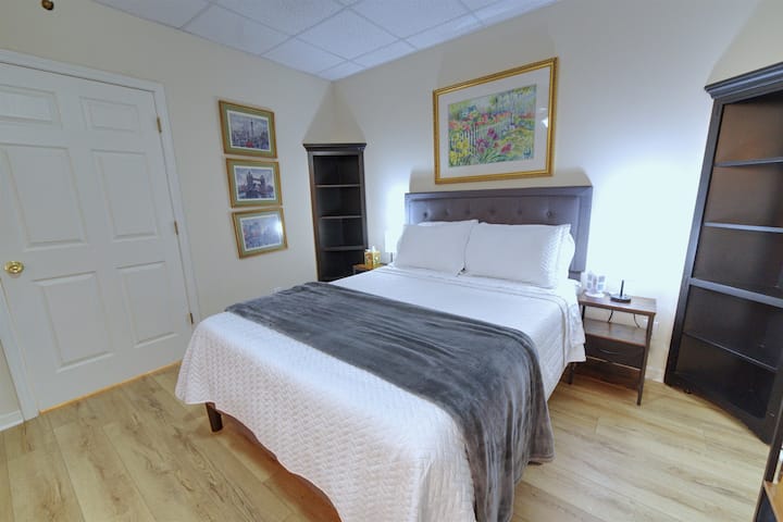 Queen Bedroom #5 accommodates 2 guests and features 70” French doors opening to a scenic backyard and patio view.