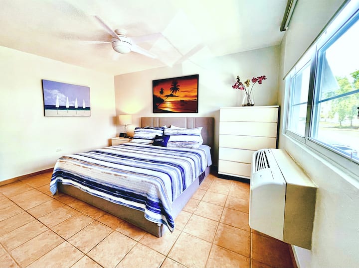 The spacious master bedroom suite has a new Bassett king bed, a walk-in closet, a clothes chest, air conditioning, a Bluetooth speaker, a ceiling fan, and a SmartTV with Roku. The full-size master bathroom is part of the master suite.